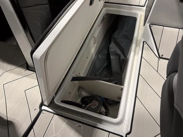 Slide: The Image of 2024 Yamaha Boats 255XE storage compartment with open hatch, showcasing interior space. - 23