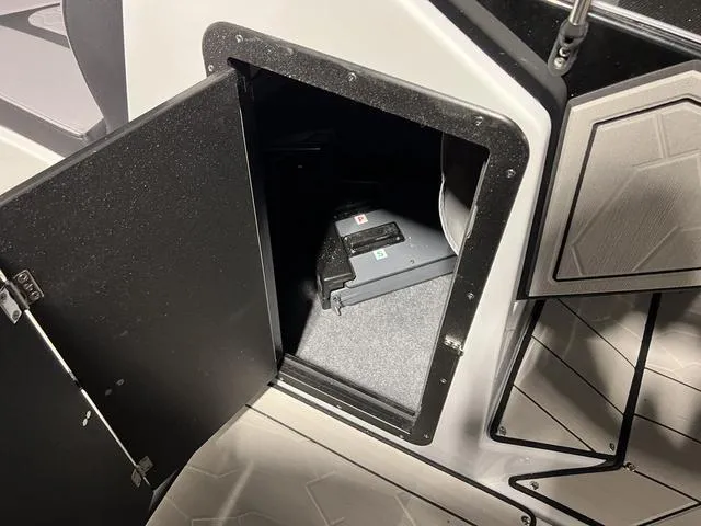 Slide: The Image of 2024 Yamaha Boats 255XE storage compartment with battery inside. - 24