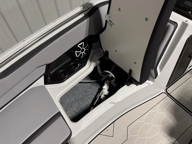 Slide: The Image of 2024 Yamaha Boats 255XE storage compartment with speaker and cup holders. - 27