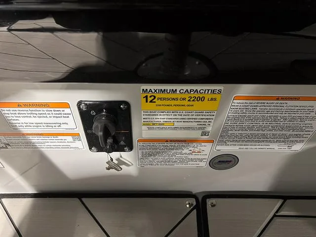 Slide: The Image of Yamaha Boats 2024 255XE capacity label, 12 persons or 2200 lbs, with ignition keys. - 30