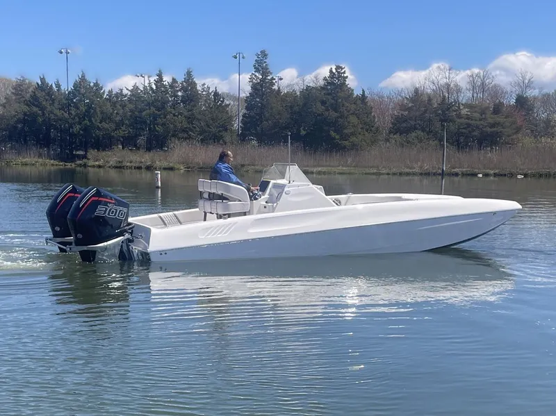 The Image of 2025 Hustler 25 C3 Speedfish boat with dual outboard engines on a calm lake. - 1