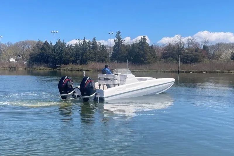 Slide: The Image of 2025 Hustler 25 C3 Speedfish boat with dual outboard motors on a calm lake. - 19