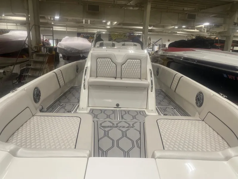 Slide: The Image of 2025 Hustler 25 C3 Speedfish boat interior with white cushioned seating and geometric flooring. - 5