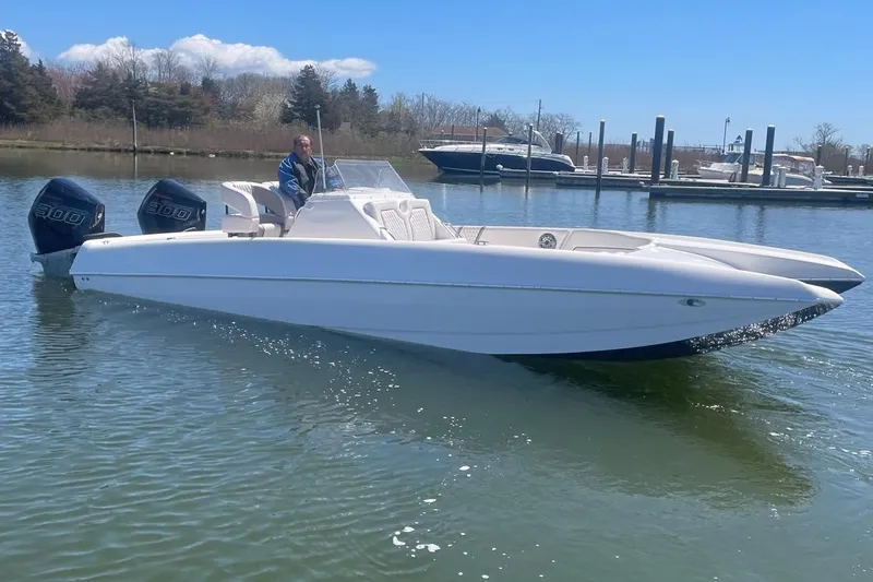 Slide: The Image of 2025 Hustler 25 C3 Speedfish boat on calm water near a marina. - 7