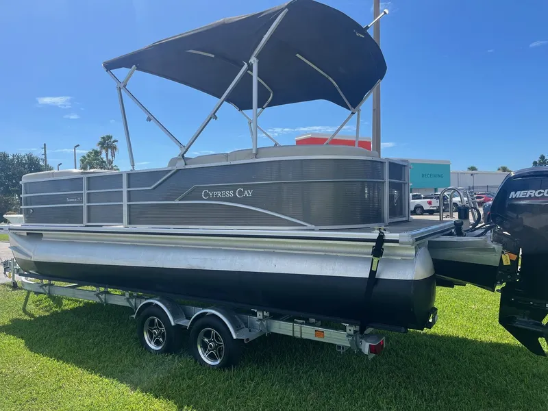 Slide: The Image of 2022 Cypress Cay Seabreeze 232 pontoon boat on a trailer under a blue sky. - 2