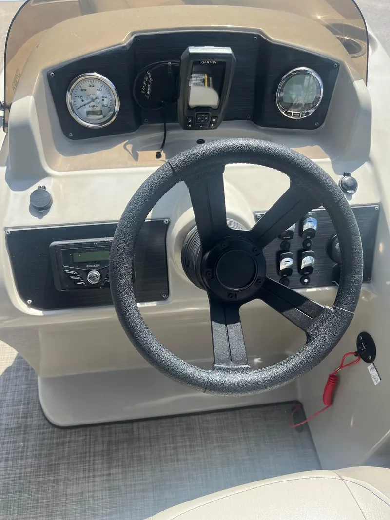 Slide: The Image of 2022 Cypress Cay Seabreeze 232 boat dashboard with steering wheel and control panel. - 8