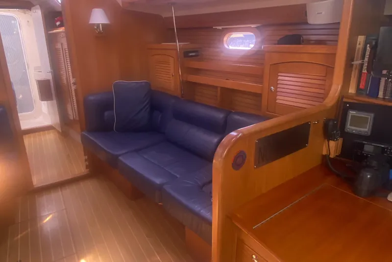 Slide: The Image of Interior of 2007 Catalina 470 yacht with blue seating and wooden finishes. - 24