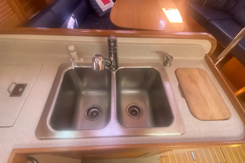 Slide: The Image of Catalina 470 yacht kitchen sink area with dual basins, faucet, and cutting board, 2007 model. - 33