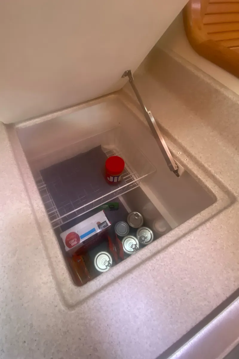 Slide: The Image of Catalina 470 (2007) yacht interior storage with canned goods and a red container. - 34