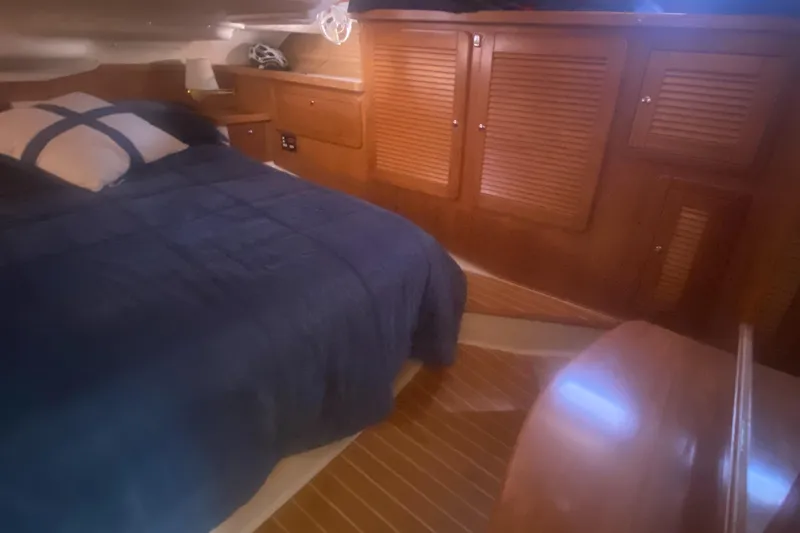 Slide: The Image of Cozy cabin interior of 2007 Catalina 470 sailboat with wooden furnishings and bed. - 42