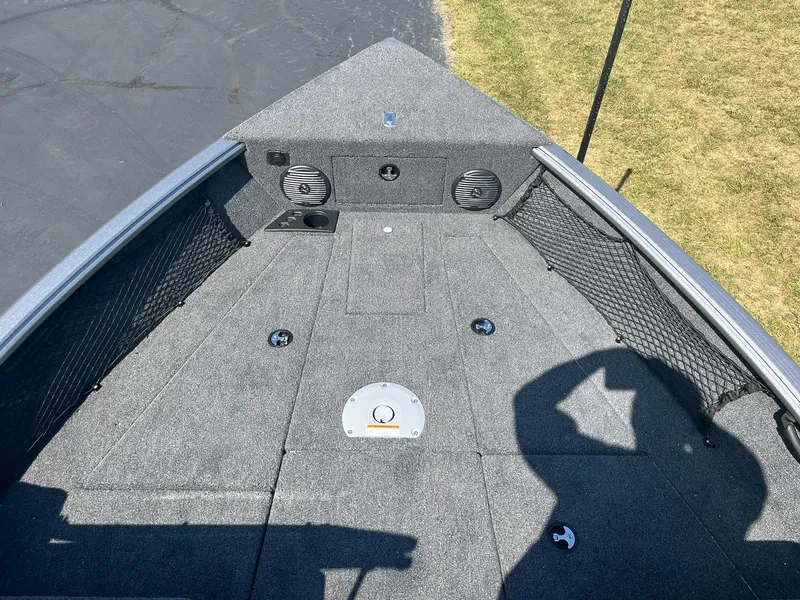 Slide: The Image of 2025 Lund 1875 Impact XS Sport boat interior with carpeted deck and storage compartments. - 13