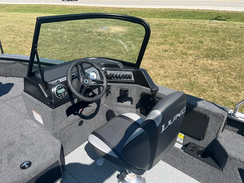 Slide: The Image of 2025 Lund 1875 Impact XS Sport boat interior with steering wheel and seat. - 16