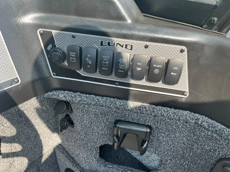Slide: The Image of Control panel of 2025 Lund 1875 Impact XS Sport boat with switches and labels. - 24