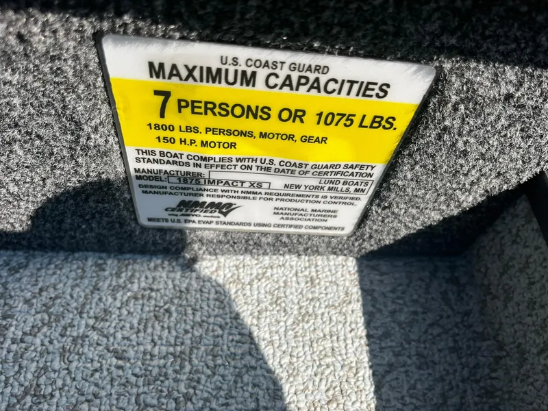 Slide: The Image of 2025 Lund 1875 Impact XS Sport capacity label, 7 persons or 1075 lbs, 150 HP motor. - 28