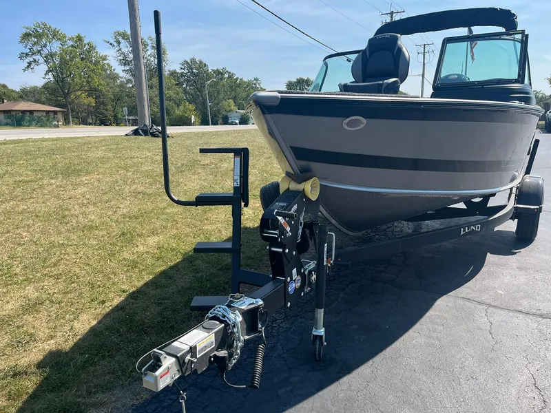 Slide: The Image of 2025 Lund 1875 Impact XS Sport boat on trailer, parked on pavement. - 3