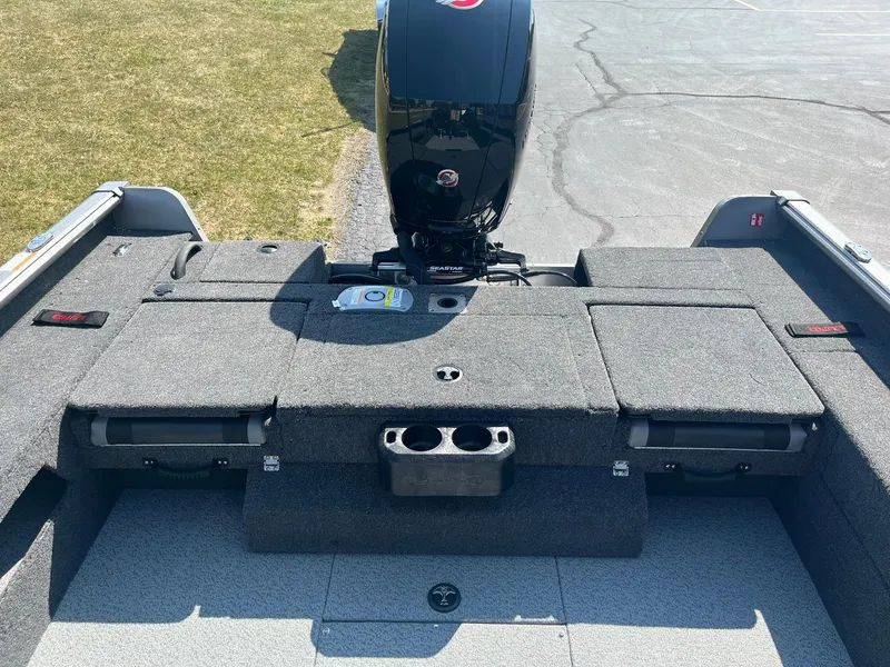 Slide: The Image of 2025 Lund 1875 Impact XS Sport boat interior with motor, gray seating, and storage compartments. - 9