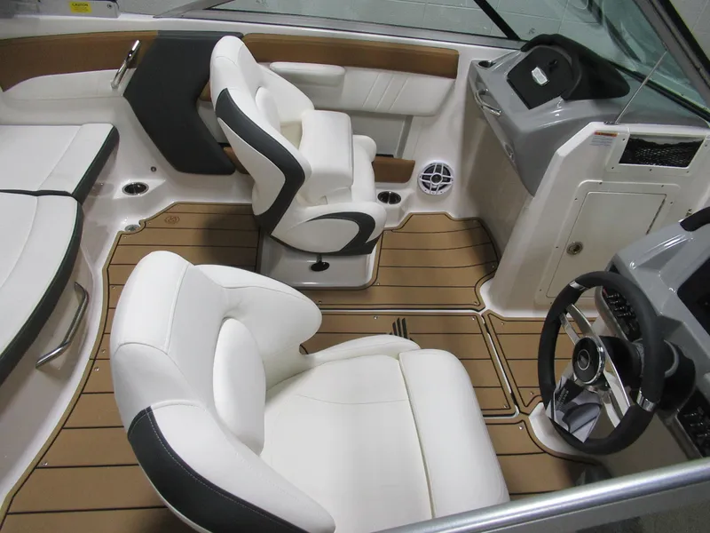 Slide: The Image of 2024 Chaparral 21 SSi boat interior with white seats and brown flooring. - 2