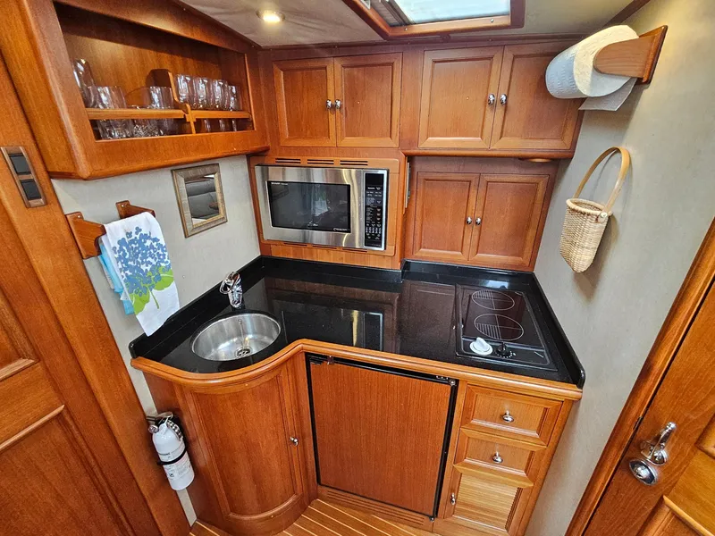 Slide: The Image of 2007 Grand Banks 39 Eastbay SX yacht kitchen with wood cabinetry and modern appliances. - 21