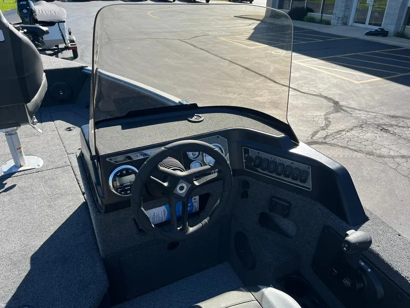 Slide: The Image of 2025 Lund 1775 Impact XS SS boat dashboard with steering wheel and controls. - 16