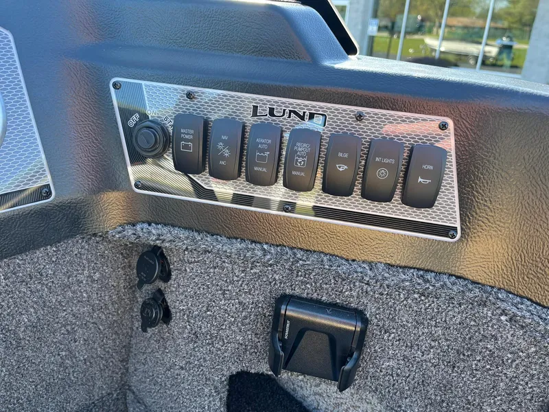 Slide: The Image of Control panel of 2025 Lund 1775 Impact XS SS boat with various switches. - 17