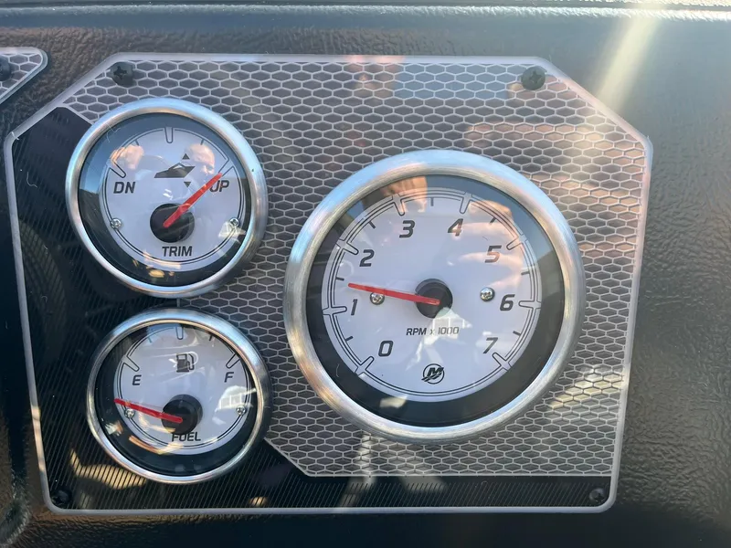 Slide: The Image of Dashboard gauges of 2025 Lund 1775 Impact XS SS boat, showing trim, fuel, and RPM. - 18