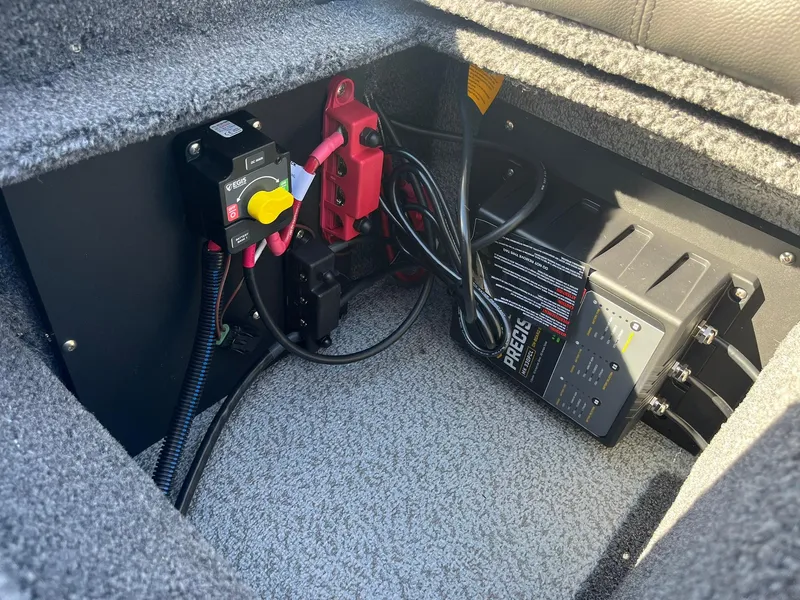 Slide: The Image of 2025 Lund 1775 Impact XS SS boat battery compartment with wiring and charger. - 27