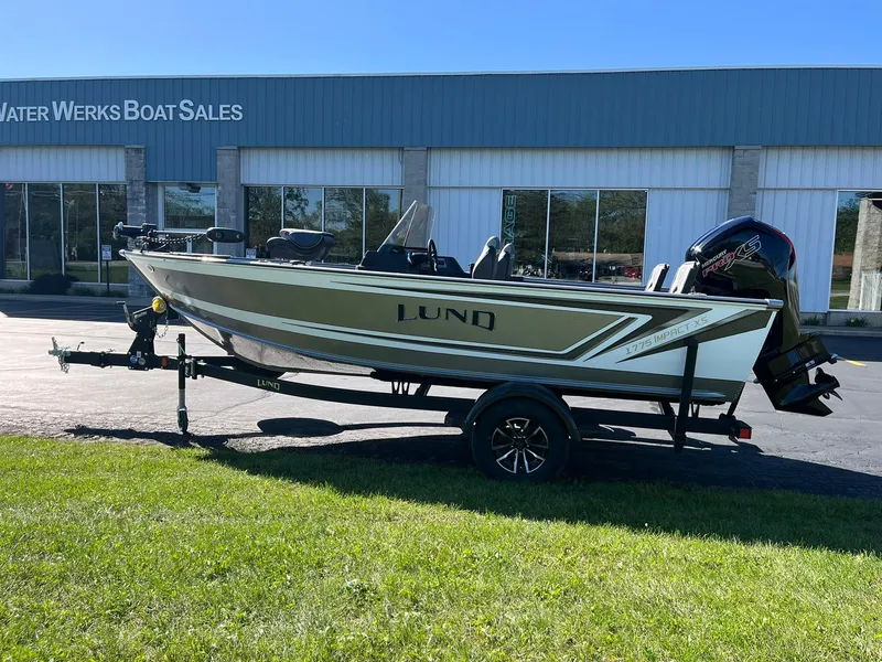 Slide: The Image of 2025 Lund 1775 Impact XS SS boat on trailer outside dealership. - 34