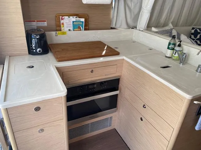 Slide: The Image of 2022 Beneteau Swift Trawler 41 Fly kitchen with modern appliances and wood cabinetry. - 11