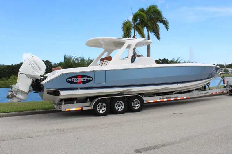 Slide: The Image of 2015 Cigarette 39 GTS boat on trailer, parked near palm trees and water. - 11