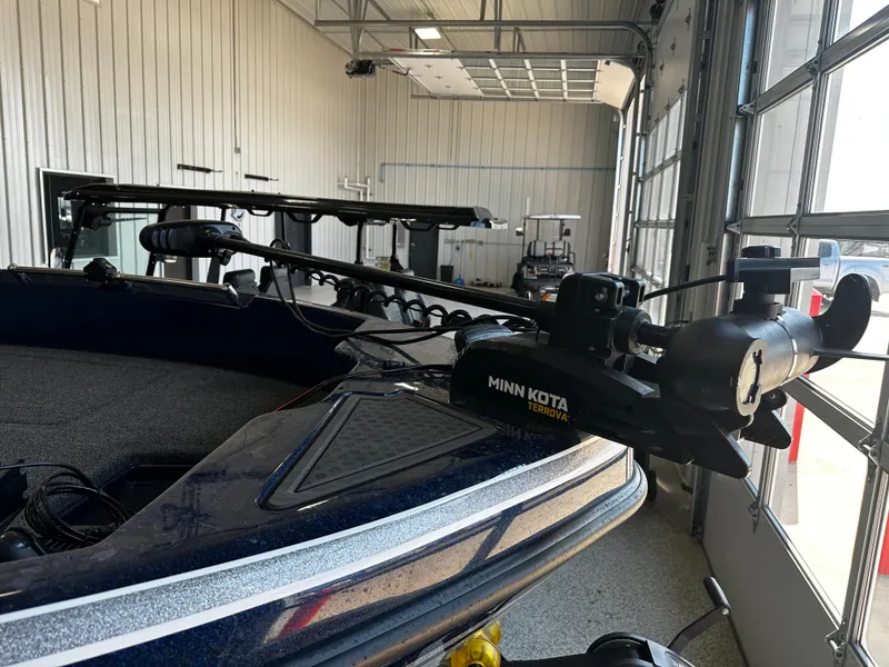 Slide: The Image of 2024 Nitro ZV19 Sport boat with Minn Kota trolling motor in a garage. - 9
