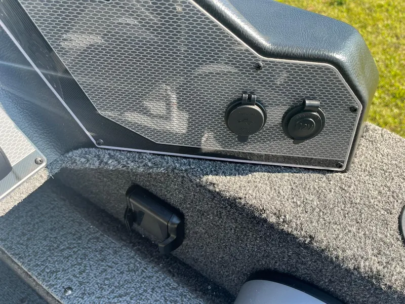 Slide: The Image of 2025 Lund 1650 Angler SS boat interior with power outlets and textured surfaces. - 16