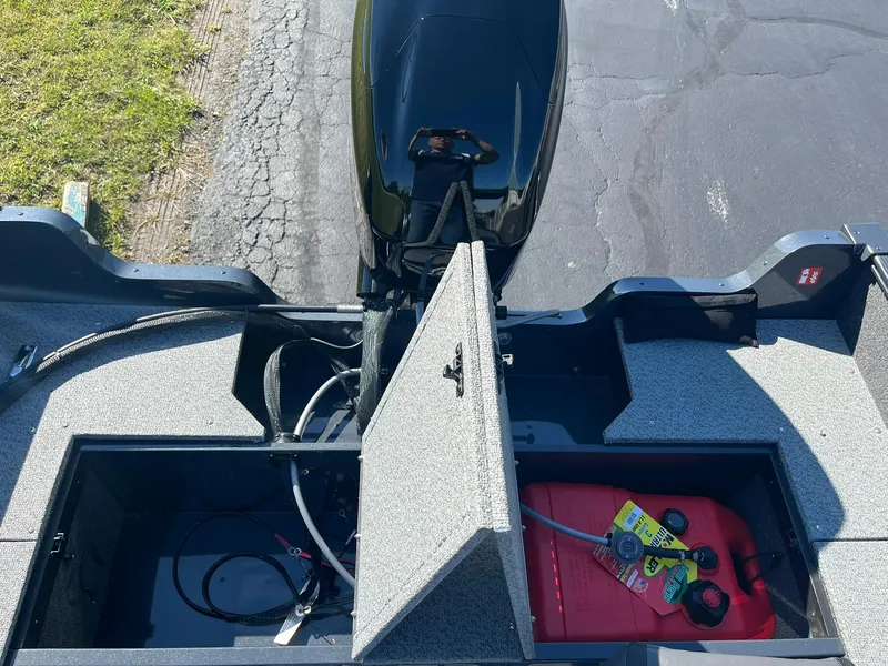 Slide: The Image of 2025 Lund 1650 Angler SS boat with open storage compartments and visible fuel tank. - 18