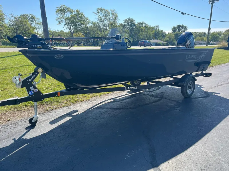 Slide: The Image of 2025 Lund 1650 Angler SS boat on trailer, parked outdoors. - 23