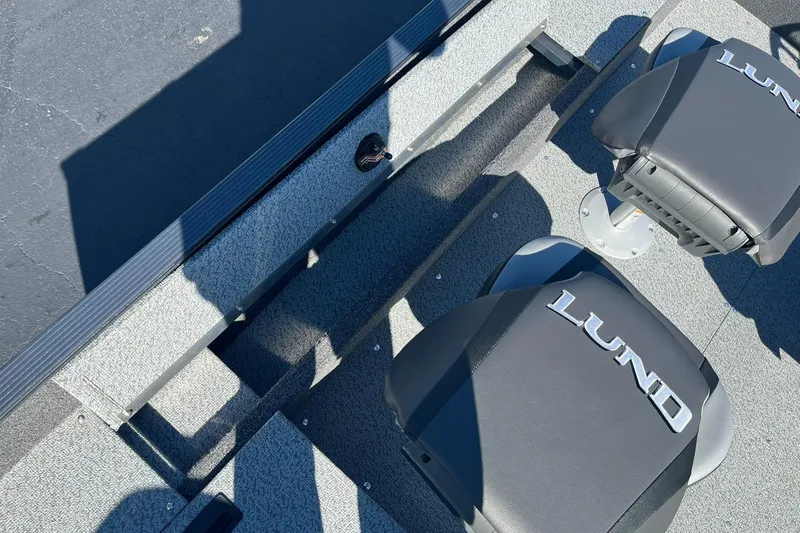 Slide: The Image of 2025 Lund 1650 Angler SS boat interior with branded seats and textured flooring. - 9