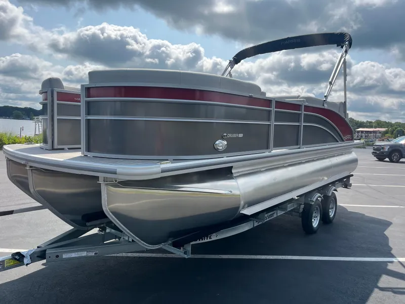 Slide: The Image of 2025 Harris Cruiser 210 pontoon boat on a trailer in a parking lot. - 5