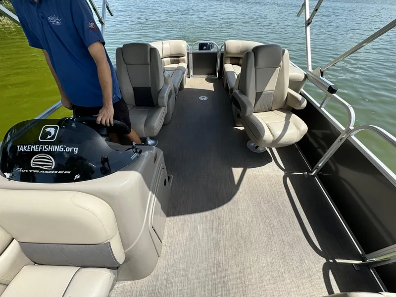 Slide: The Image of 2023 Sun Tracker Party Barge 24 DLX pontoon boat interior with seating and steering console. - 7