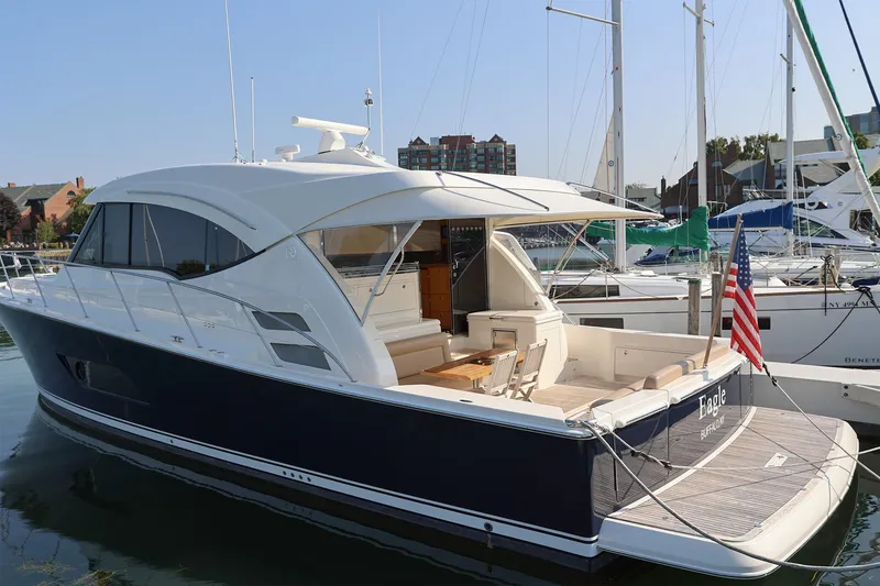 Slide: The Image of 2016 Riviera 525 SUV yacht docked at marina, featuring sleek design and American flag. - 30