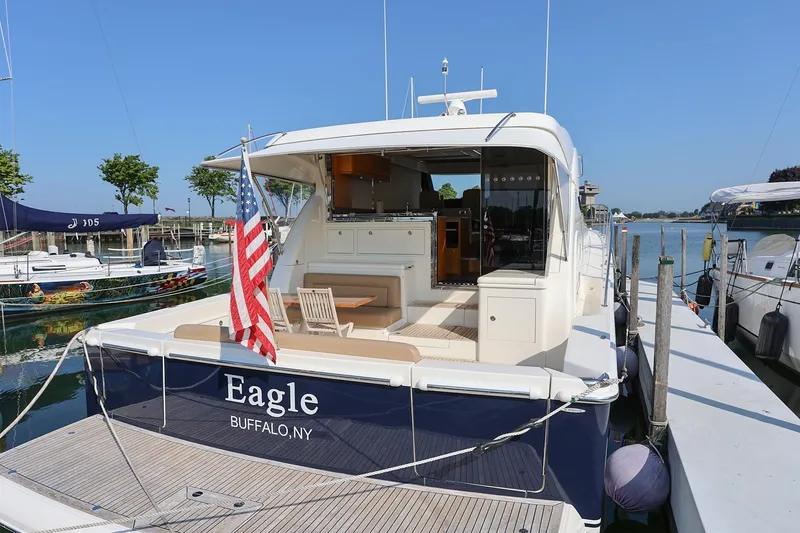 Slide: The Image of 2016 Riviera 525 SUV yacht docked, rear view with American flag, named "Eagle" in Buffalo, NY. - 31