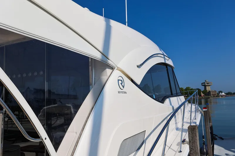 Slide: The Image of 2016 Riviera 525 SUV yacht docked by calm waters, showcasing sleek design and luxury features. - 35