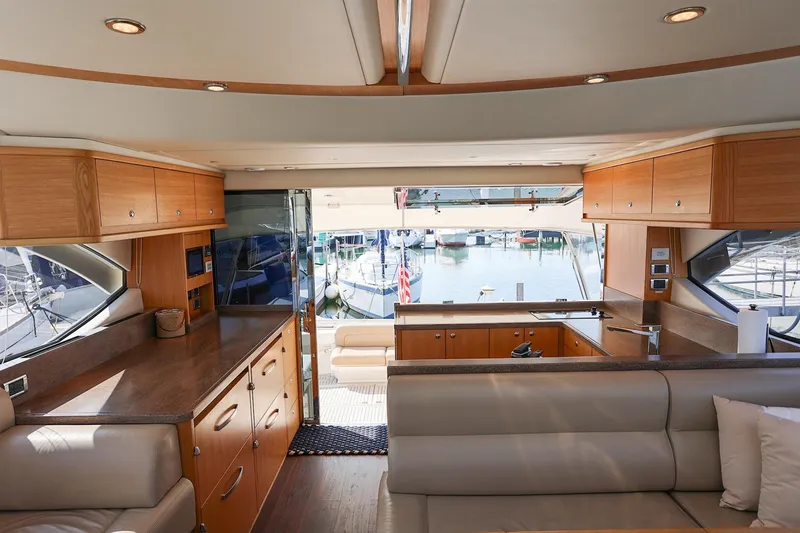 Slide: The Image of Interior of 2016 Riviera 525 SUV yacht with modern wood cabinetry and marina view. - 47