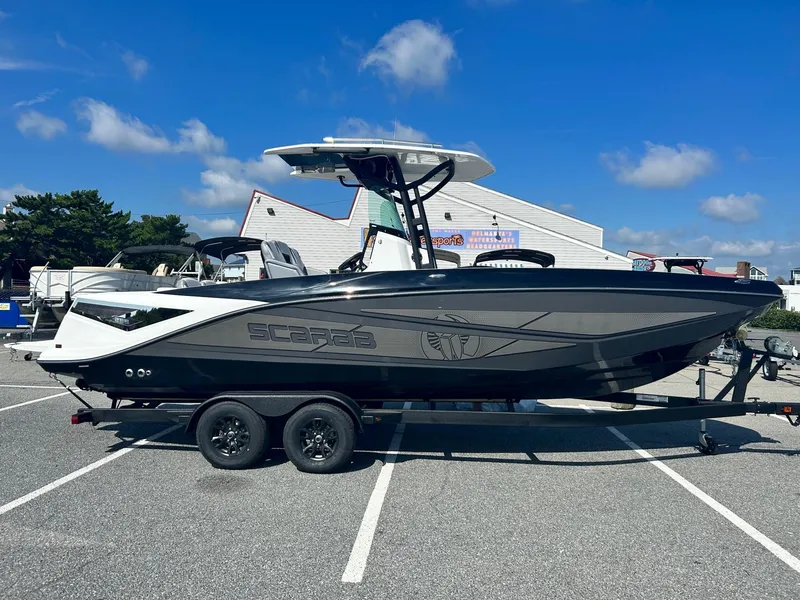 The Image of 2024 Scarab 255 Open ID boat on a trailer in a parking lot. - 0