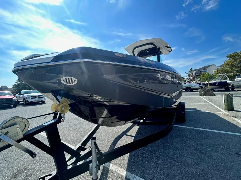 Slide: The Image of 2024 Scarab 255 Open ID boat on a trailer in a parking lot. - 2