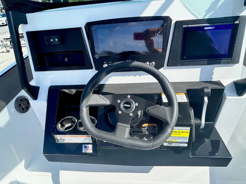 Slide: The Image of 2024 Scarab 255 Open ID boat dashboard with steering wheel and navigation screens. - 21