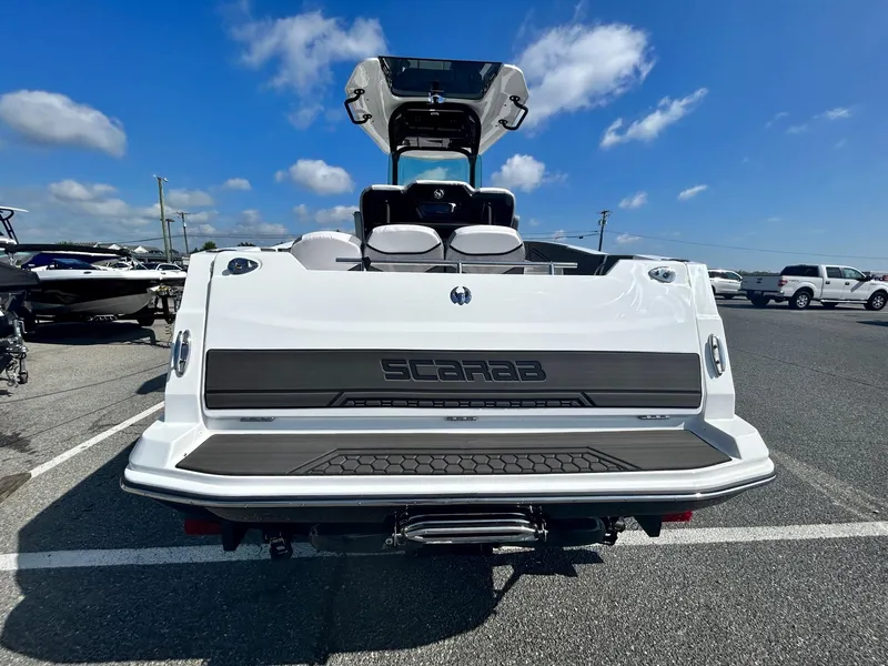 Slide: The Image of 2024 Scarab 255 Open ID boat rear view in a parking lot. - 22