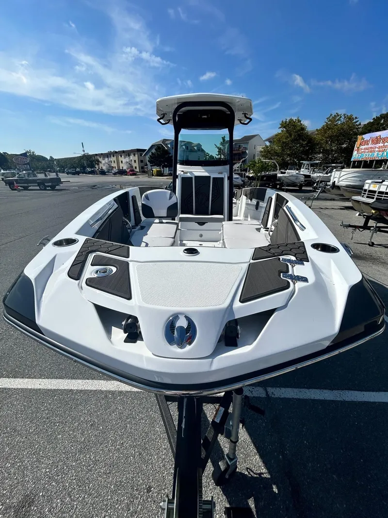 Slide: The Image of 2024 Scarab 255 Open ID boat in a parking lot under a clear blue sky. - 3