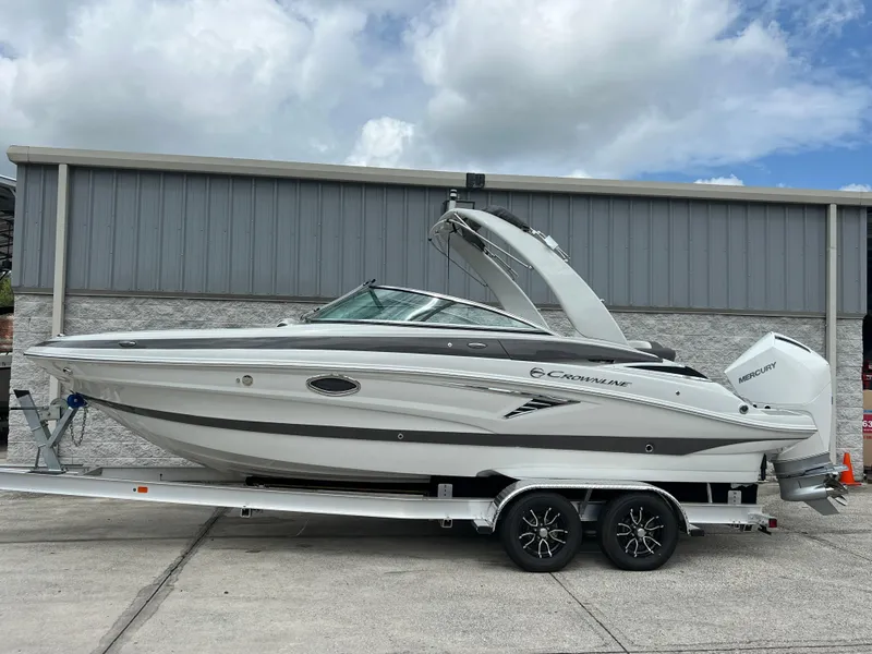The Image of 2024 Crownline 250 XSS boat on a trailer, parked outdoors. - 0