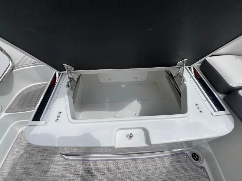 Slide: The Image of 2024 Crownline 250 XSS boat storage compartment open. - 12