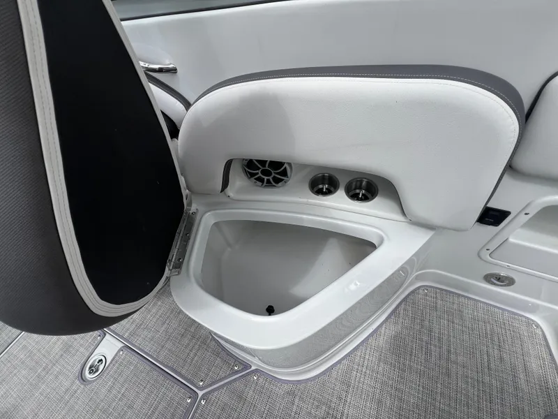 Slide: The Image of 2024 Crownline 250 XSS boat interior with storage compartment and cup holders. - 13