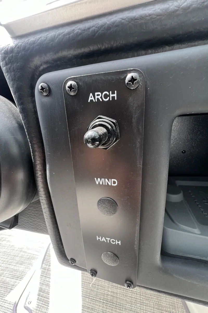 Slide: The Image of Control panel of a 2024 Crownline 250 XSS boat with arch, wind, and hatch switches. - 26