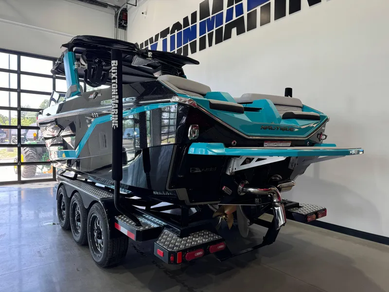 Slide: The Image of 2025 Nautique Super Air Nautique G25 boat on a trailer in a showroom. - 5